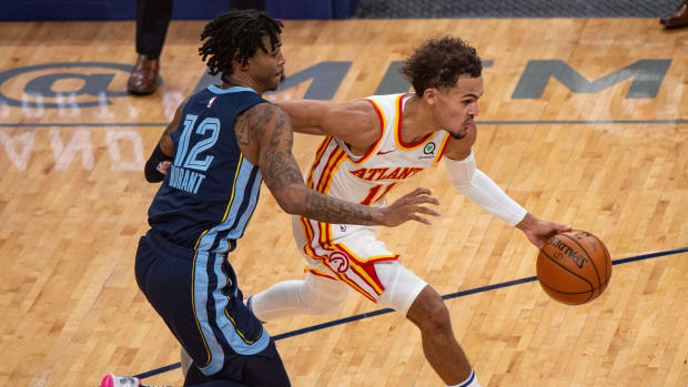 Atlanta Hawks guard Trae Young dribbles past Memphis Grizzlies guard Ja Morant.